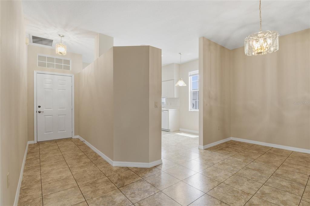 An entryway with tile flooring leads to a dining area and a kitchen beyond — 6700 E KINGSBURY LANE, INVERNESS, FL