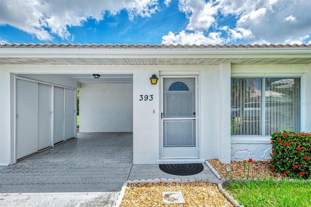 The exterior of a single-story home features a carport, a front door, and a window — 393 CIRCLEWOOD DRIVE UNIT Z3, VENICE, FL