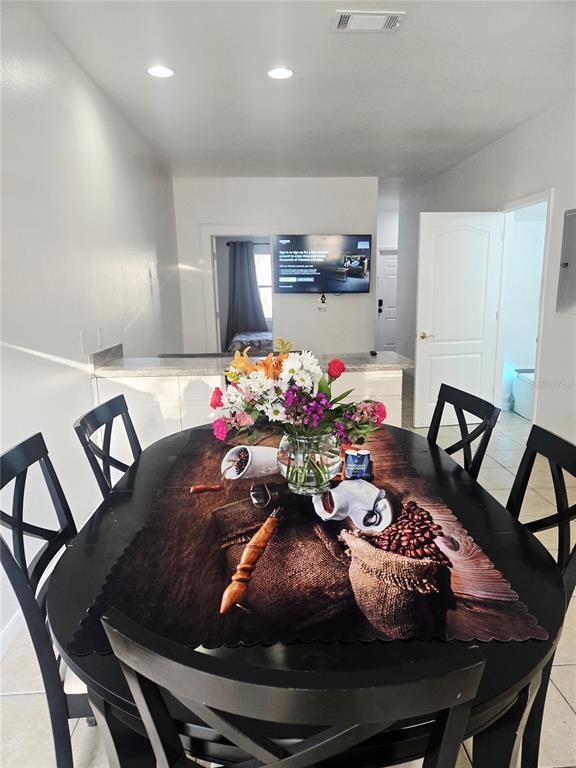 A dining area features a black table with a floral centerpiece and chairs — 13612 N 21ST STREET UNIT 2, TAMPA, FL