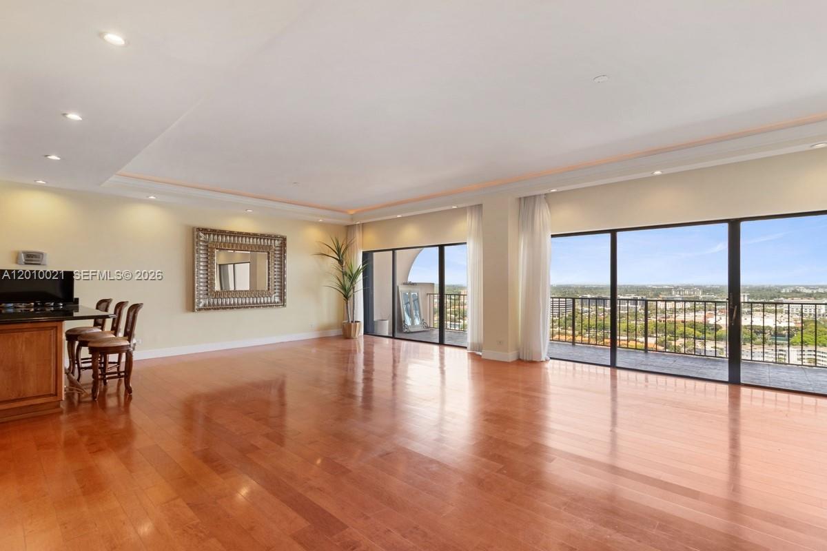 A spacious living room features hardwood floors, recessed lighting, and large sliding glass balcony doors — 1800 NE 114th St, Miami FL 33181, MIAMI, FL