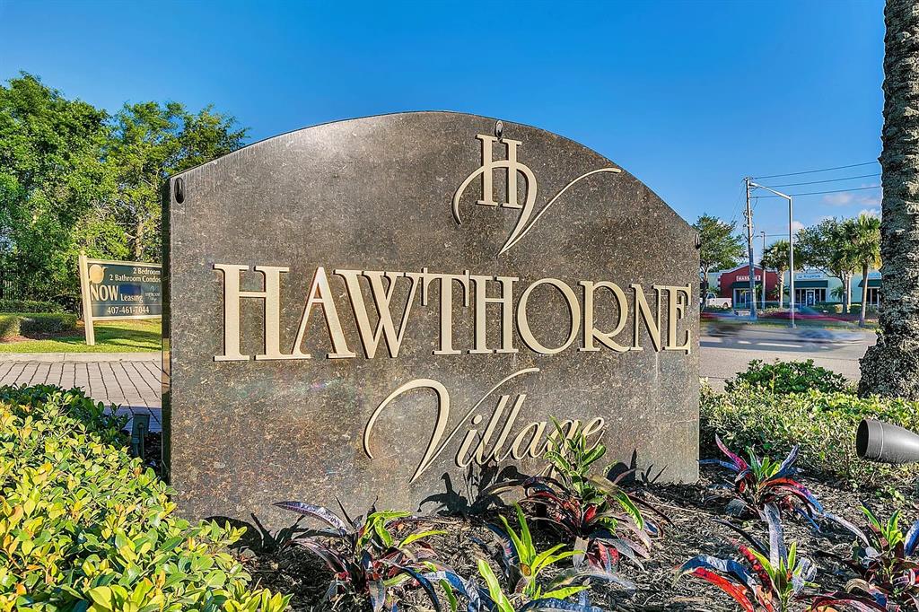 A stone monument sign for Hawthorne Village stands in a landscaped garden area — 2401 BARLEY CLUB DRIVE UNIT GE, ORLANDO, FL
