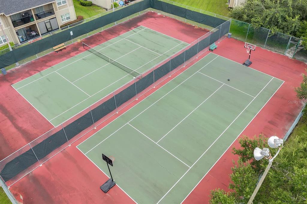 An aerial view shows two outdoor tennis courts with a basketball hoop and perimeter fencing — 2401 BARLEY CLUB DRIVE UNIT GE, ORLANDO, FL