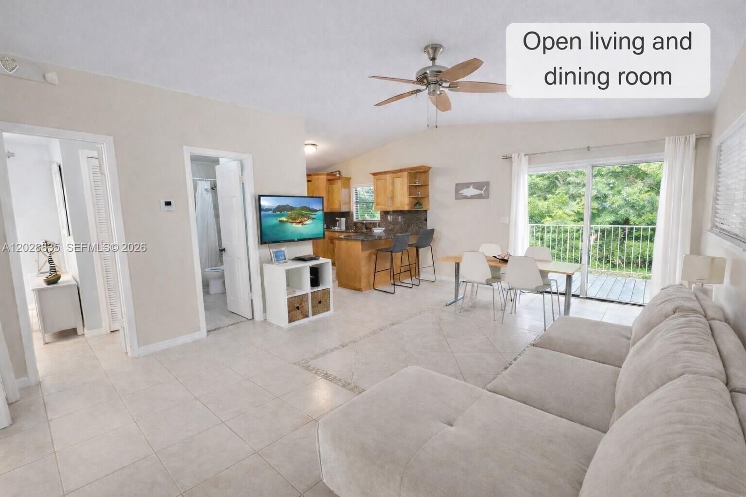 An open-concept living and dining area features tile flooring, a ceiling fan, and a kitchen — 335 Bay View Ave, Key Largo FL 33037, KEY LARGO, FL