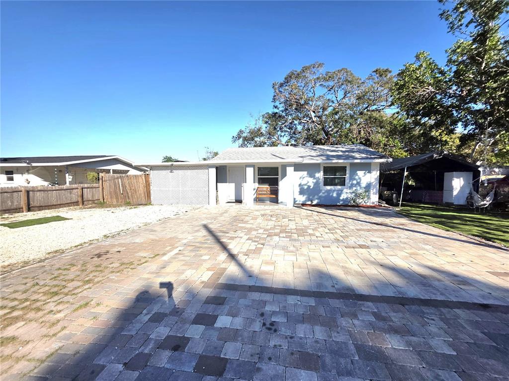 A single-story house with a paved driveway and a covered carport under a clear sky — 2137 4TH STREET E, BRADENTON, FL