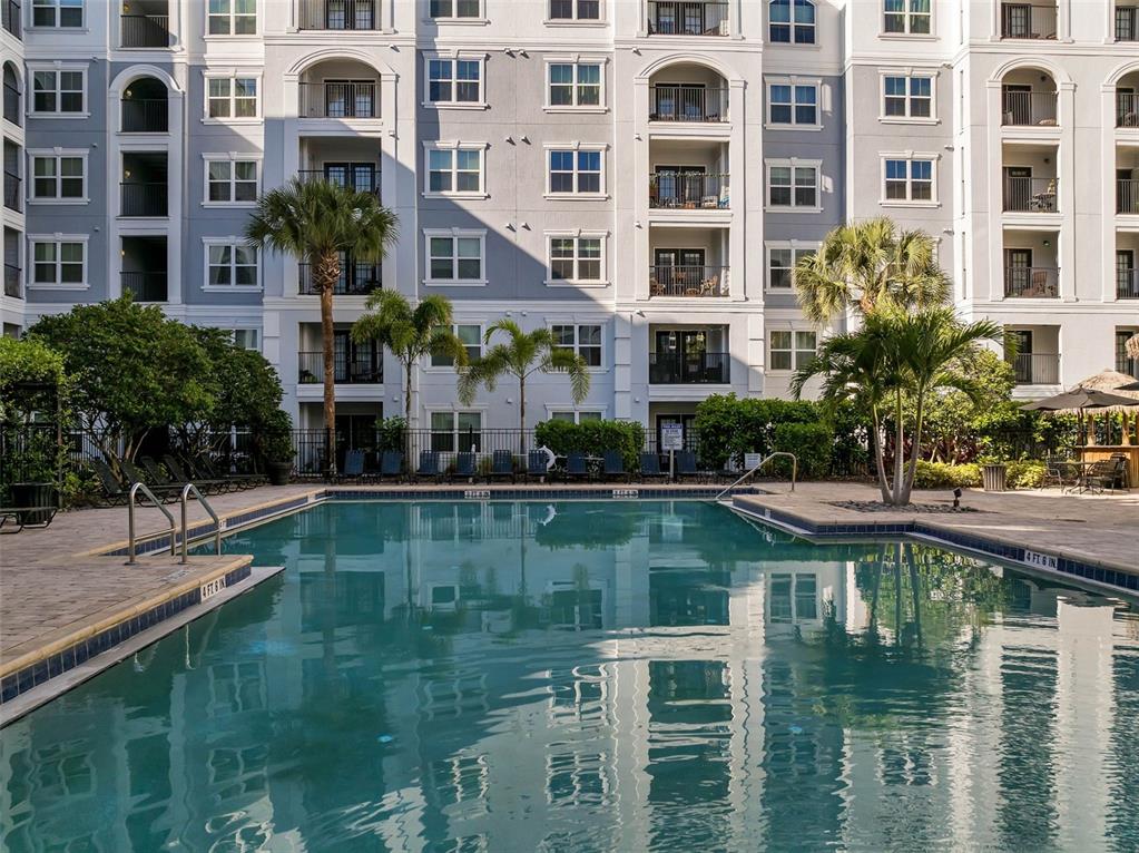 A black front door with a keypad lock is located in a white-walled apartment hallway — 300 E SOUTH STREET UNIT 1003, ORLANDO, FL
