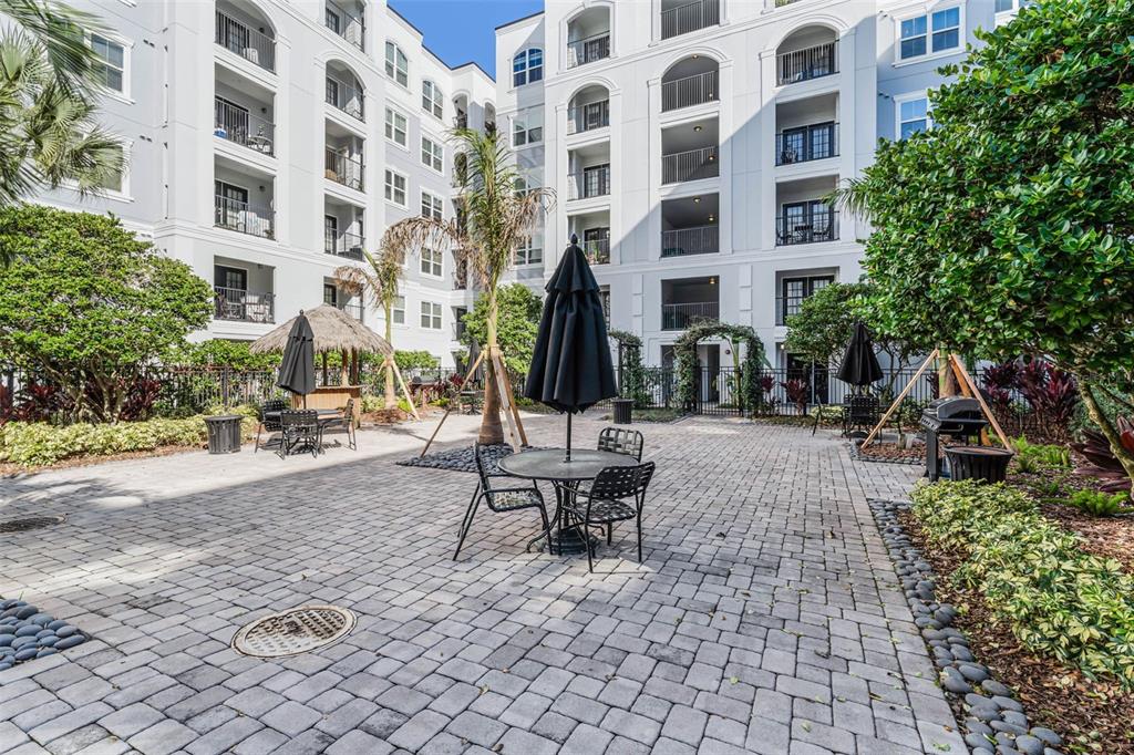 A black front door with a lockbox is situated in a white-walled apartment hallway — 300 E SOUTH STREET UNIT 1003, ORLANDO, FL