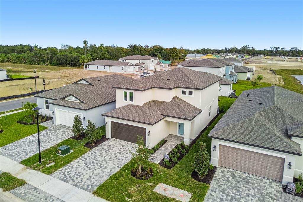 An aerial view shows a two-story suburban house with a paved driveway and landscaped yard — 9118 OPTIMIST WAY, PALMETTO, FL