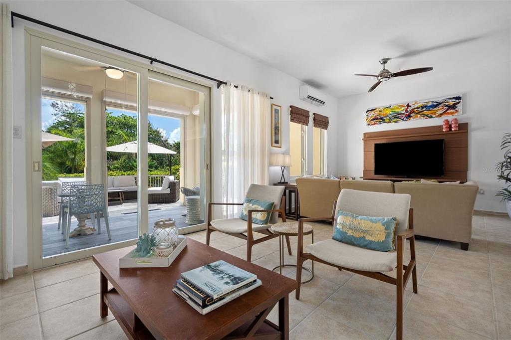 A living room features a coffee table, two armchairs, a sofa, and a sliding glass door — 90 CANDELERO DRIVE UNIT 62, HUMACAO, PR