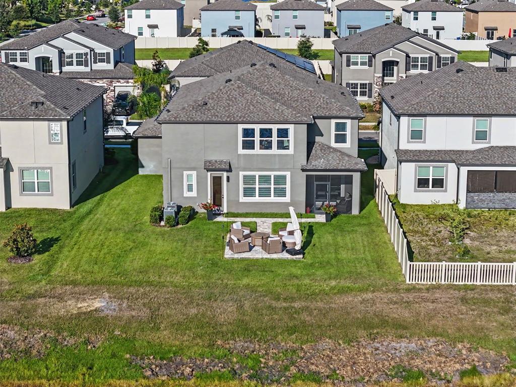 A kitchen with dark wood cabinets, granite countertops, and an island overlooks a dining area — 3117 KING FERN DRIVE, WIMAUMA, FL