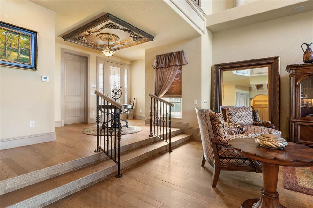 A foyer with a raised entryway, ornate ceiling medallion, and hardwood flooring — 224 YACHT HARBOR DRIVE, PALM COAST, FL