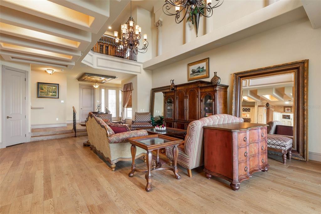 A spacious living room features high ceilings, wood flooring, a large mirror, and traditional furniture — 224 YACHT HARBOR DRIVE, PALM COAST, FL