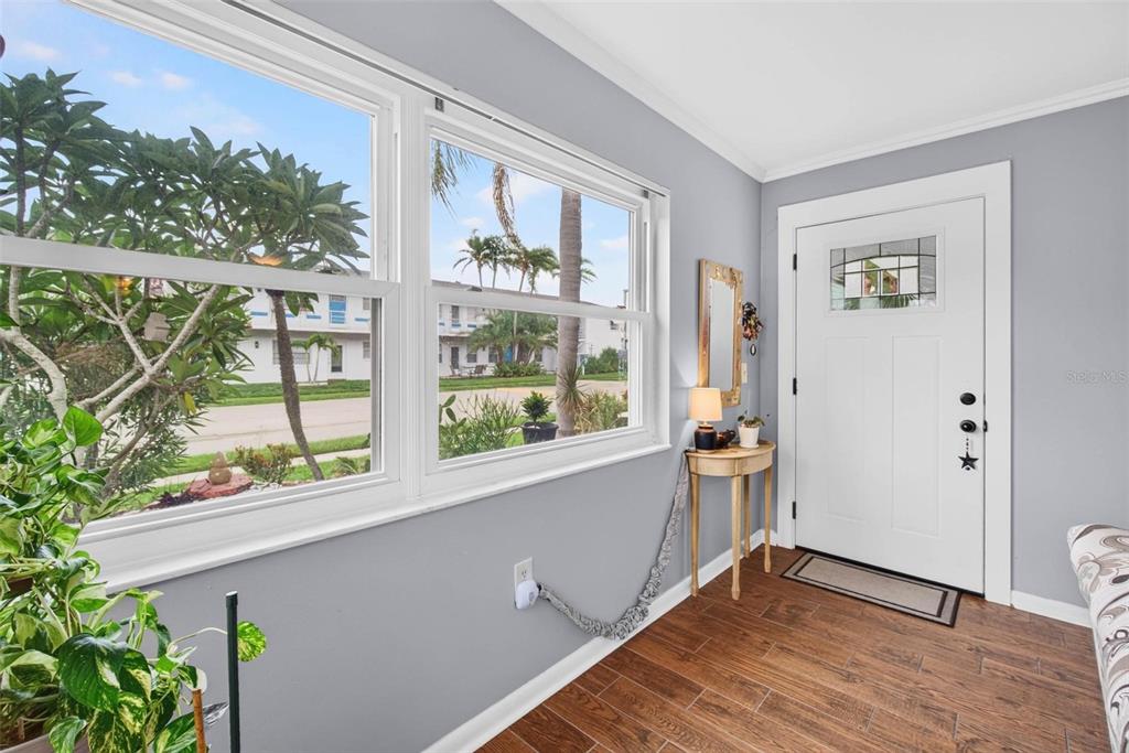 An entryway with gray walls, wood-look tile flooring, a white front door, and large windows — 1900 58TH AVENUE N UNIT 14, ST PETERSBURG, FL