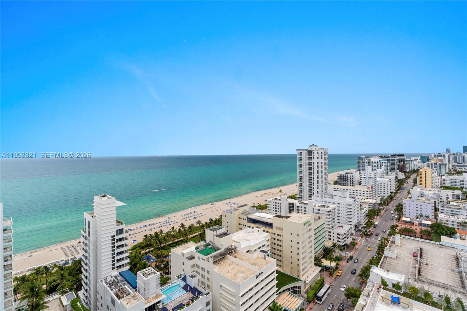 An aerial view shows a coastal city with high-rise buildings, a sandy beach, and the ocean — 4401 Collins Ave, Miami Beach FL 33140, MIAMI BEACH, FL
