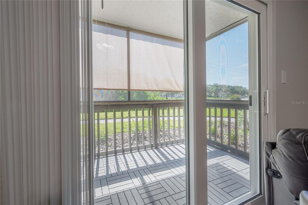 A sliding glass door opens onto a screened balcony with gray interlocking deck tiles — 9100 DR MARTIN LUTHER KING JR STREET N UNIT 905, ST PETERSBURG, FL