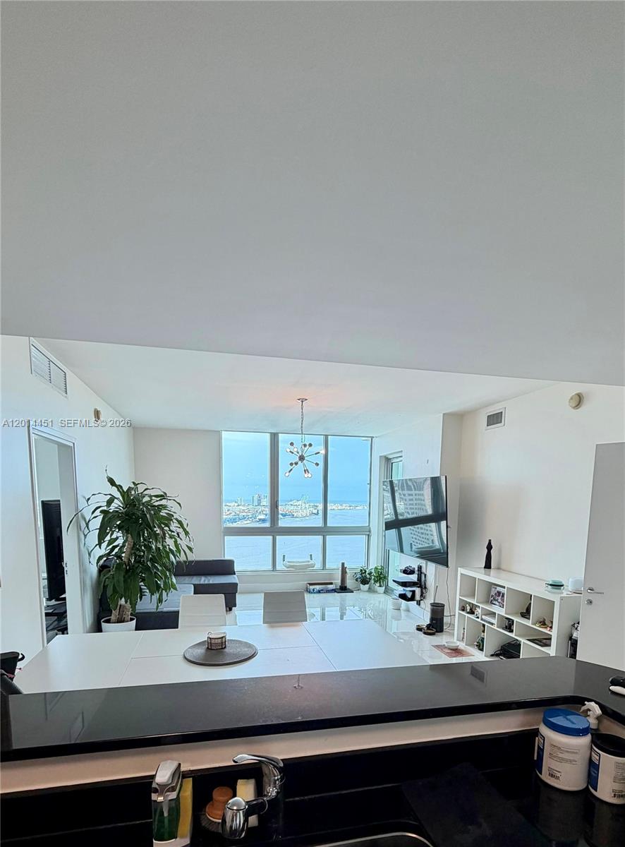 A modern dining and living area features a large window with a coastal city view — 300 S Biscayne Blvd # 3212, Miami FL 33131, MIAMI, FL