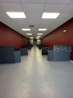 An empty commercial space features dark red walls, gray flooring, and multiple dark reception desks — 1507 AURORA ROAD UNIT 102, MELBOURNE, FL
