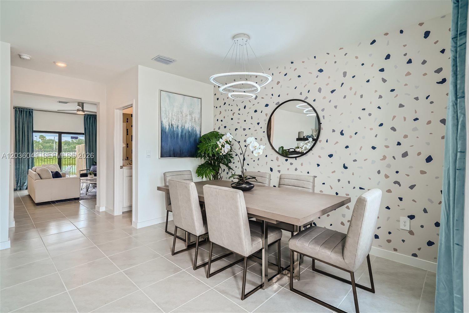 A dining room features a patterned accent wall, a modern chandelier, and a wooden table — 1366 NE 4th Ave, Florida City FL 33034, FLORIDA CITY, FL