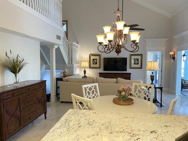 A dining area and living room feature a chandelier, granite countertop, and neutral furniture — 2502 N Fairway Dr Drive N, Jupiter FL 33477, JUPITER, FL