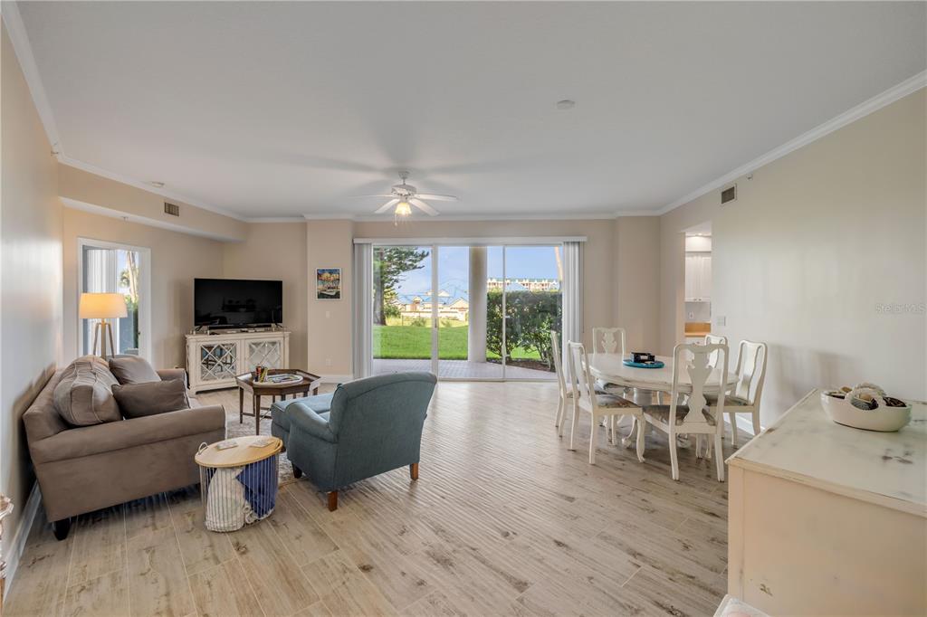 A living and dining room with tile floors, a ceiling fan, and sliding glass doors — 4650 LINKS VILLAGE DRIVE UNIT B103, PONCE INLET, FL