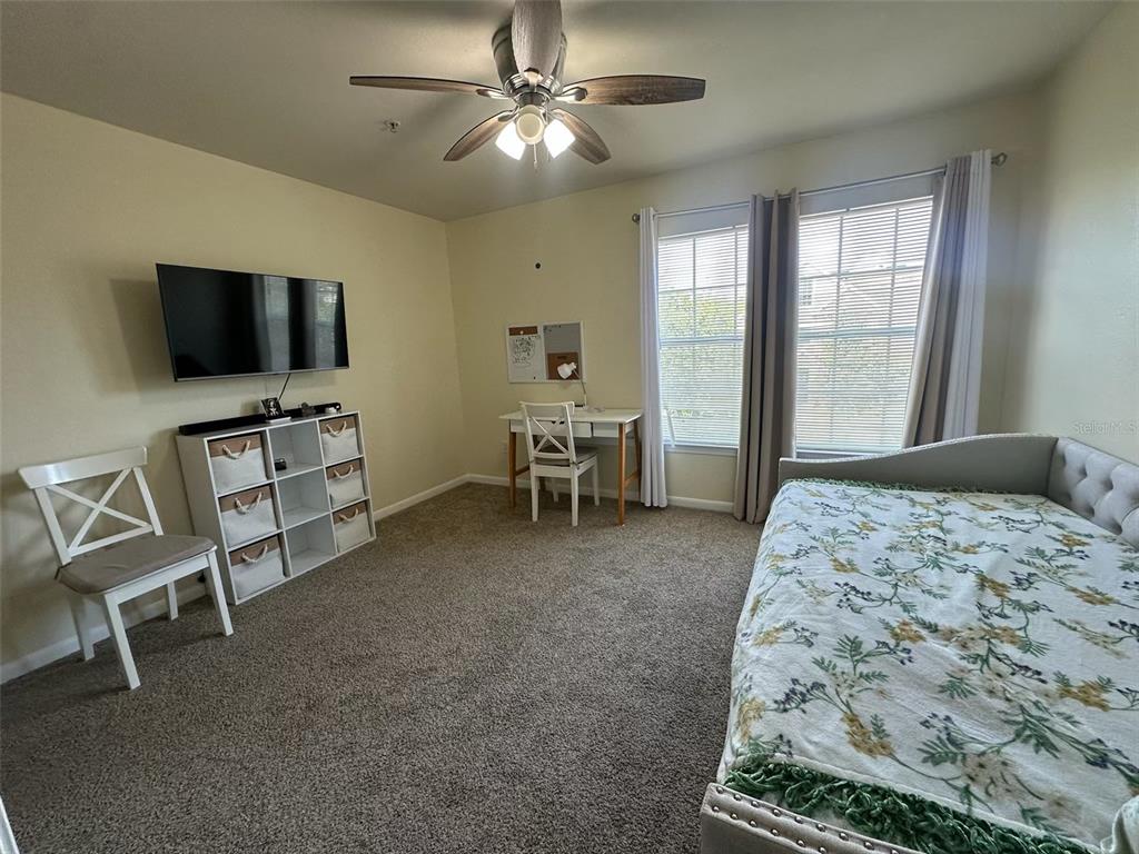 A bedroom features a daybed, a desk, a storage unit, and a ceiling fan — 9005 LEE VISTA BOULEVARD UNIT 1805, ORLANDO, FL