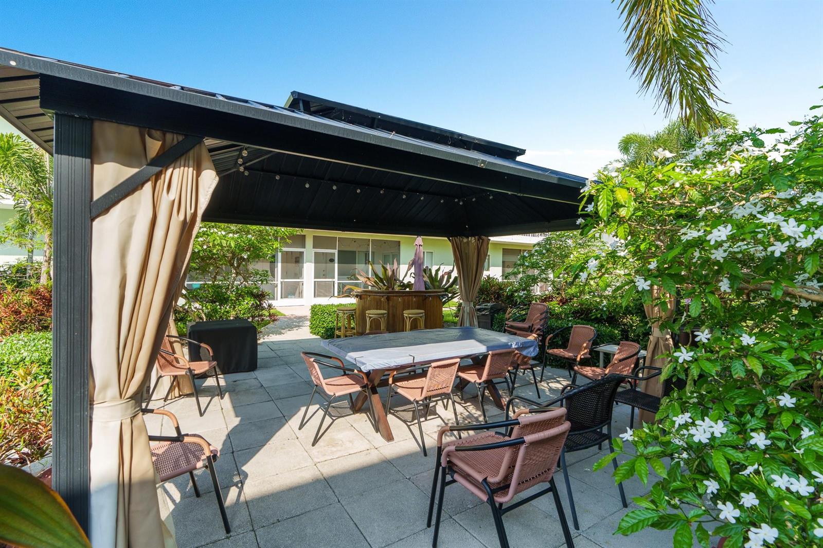 A patio features a metal gazebo covering a dining table and chairs near a bar — 2100 NE 38th Street # 243, Lighthouse Point FL 33064, LIGHTHOUSE POINT, FL