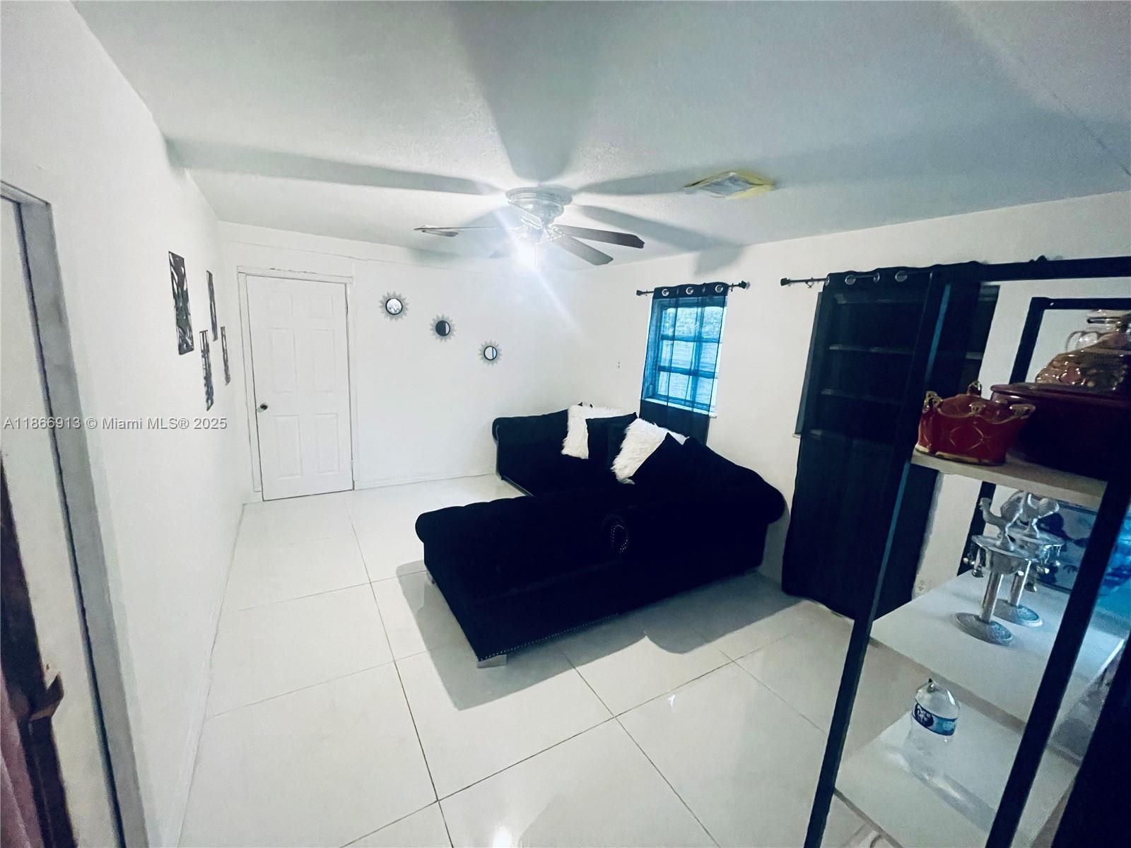 A living room features white tile floors, a black sectional sofa, and a ceiling fan — 2751 NW 99th St, Miami FL 33147, MIAMI, FL