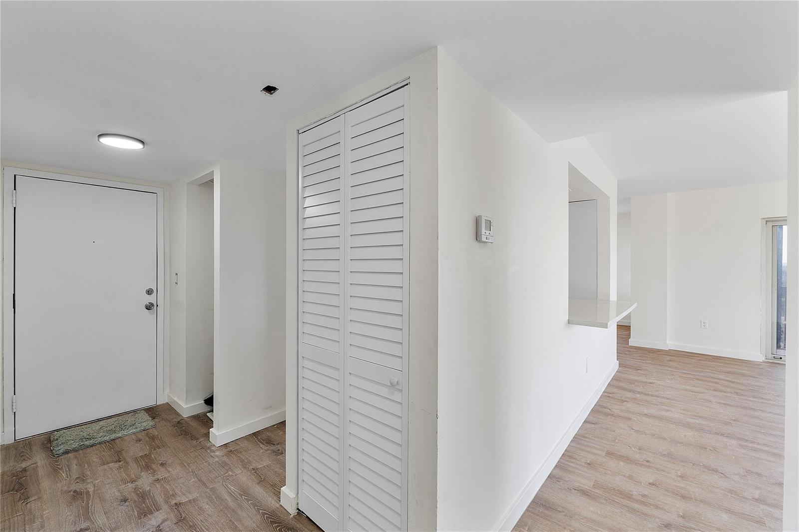 An interior view shows a white door, a louvered closet, and a kitchen pass-through window — 4174 Inverrary Drive # 1002, Lauderhill FL 33319, LAUDERHILL, FL