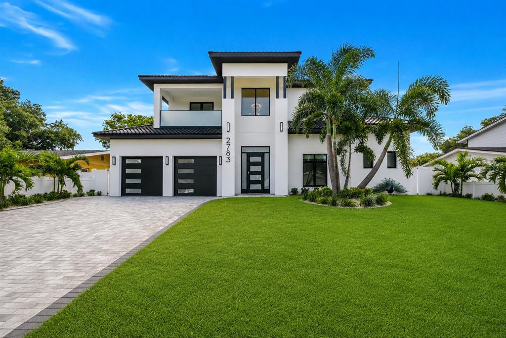 A modern two-story house with a white exterior, black accents, and a paved driveway — 2783 67TH WAY N, ST PETERSBURG, FL