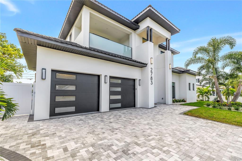 A modern two-story house with a paved driveway, two garage doors, and a balcony — 2783 67TH WAY N, ST PETERSBURG, FL