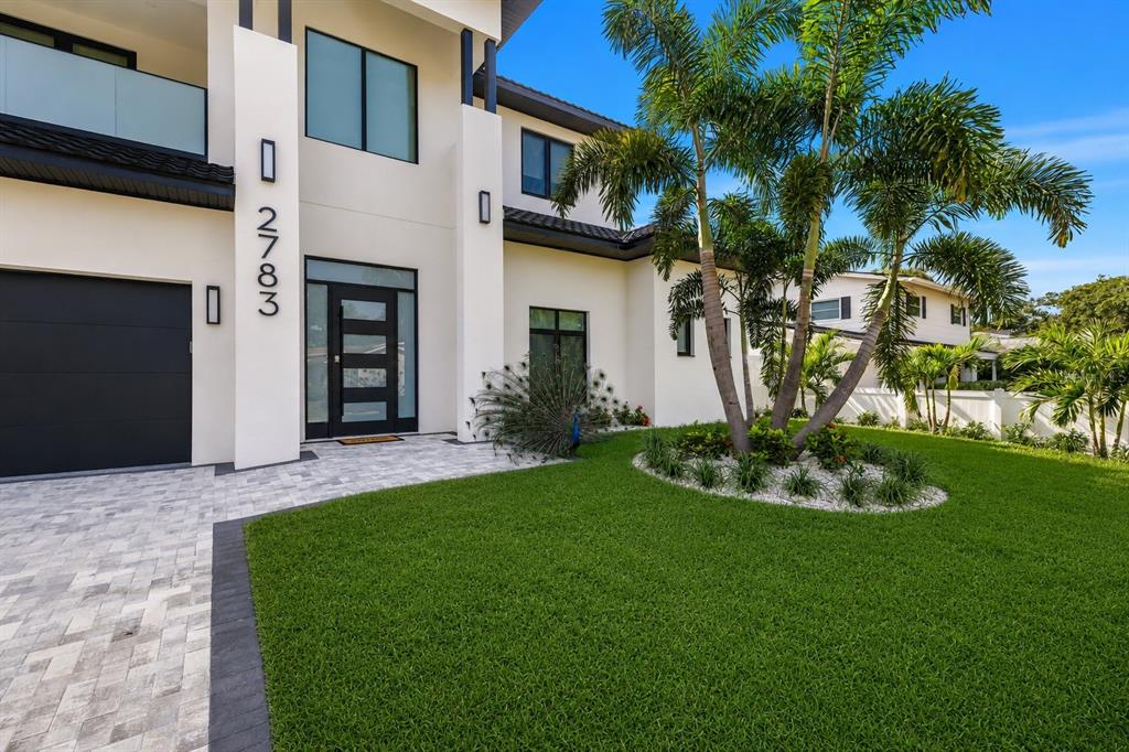 A modern two-story house with a white exterior, black accents, and a palm tree garden — 2783 67TH WAY N, ST PETERSBURG, FL