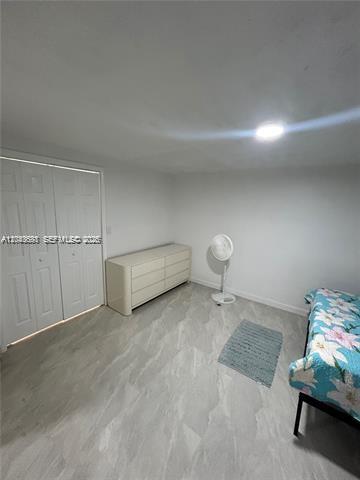 A bedroom with white walls, light wood-look flooring, a dresser, a fan, and a bed — 6773 Dogwood Dr # 1, Miramar FL 33023, MIRAMAR, FL