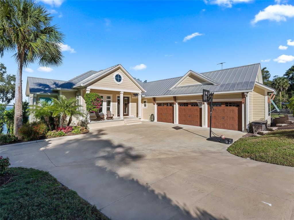 A sandy beach leads to a wooden dock extending into a large lake — 12943 SE SUNSET HARBOR ROAD, WEIRSDALE, FL