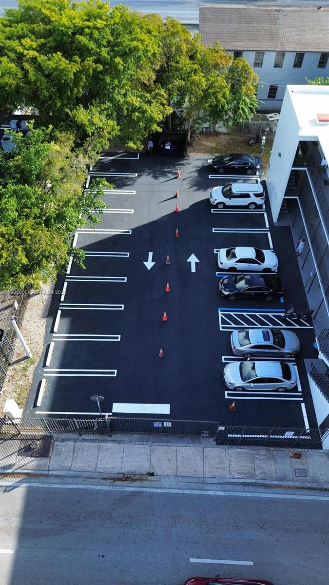 An aerial view shows a paved parking lot with marked spaces and orange traffic cones — 1130 NW 62nd St # 15, Miami FL 33150, MIAMI, FL