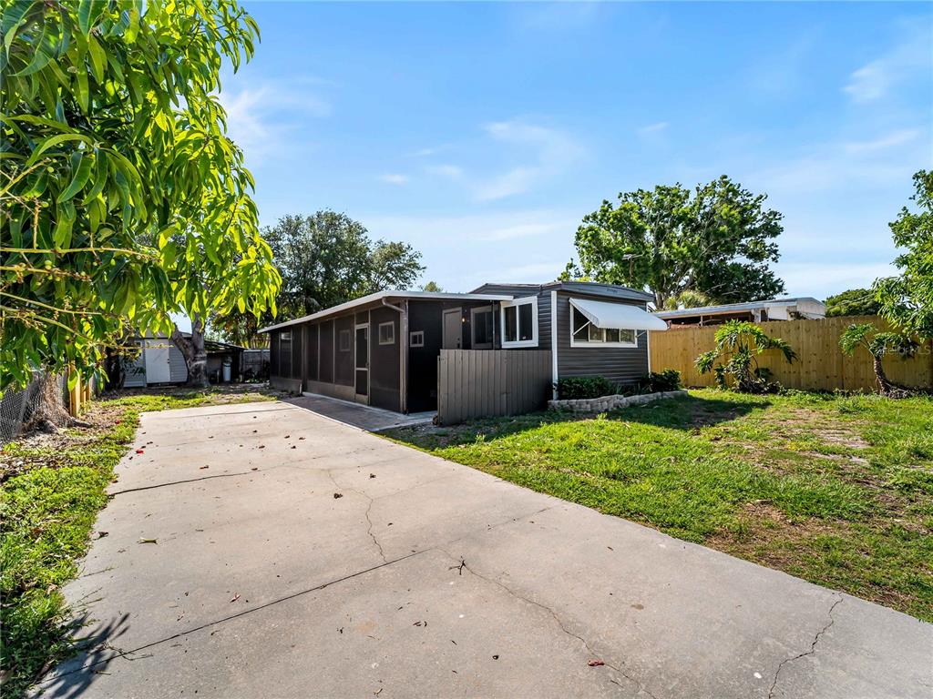 A single-story mobile home with a screened porch and concrete driveway sits on a lot — 110 VERONA STREET N, NOKOMIS, FL