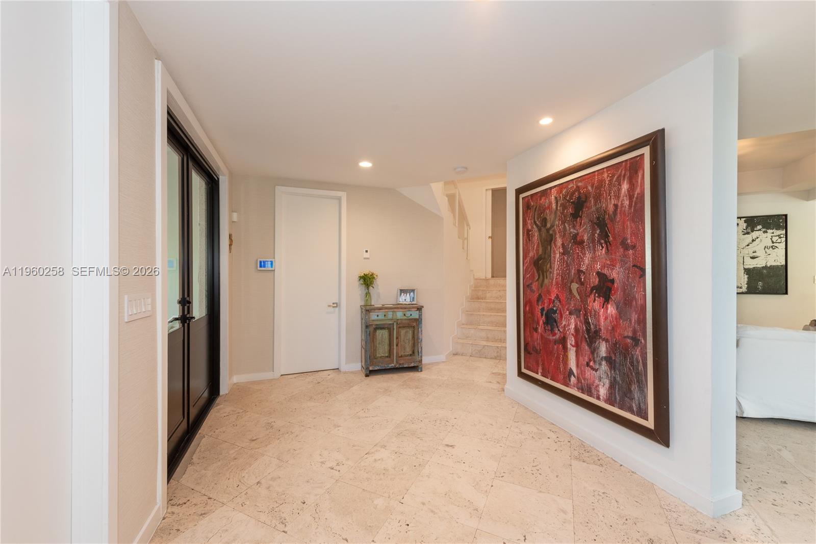 An entryway features tile flooring, a large red abstract painting, and a staircase — 650 Curtiswood Dr, Key Biscayne FL 33149, KEY BISCAYNE, FL