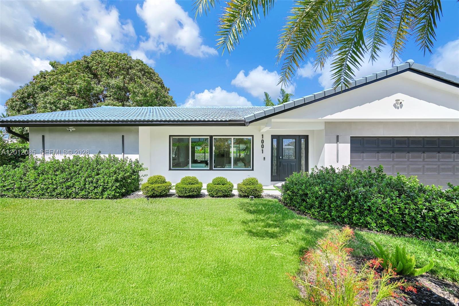 A single-story house with a blue tiled roof, white exterior, and a manicured front lawn — 1001 NW 4th Ct, Boca Raton FL 33432, BOCA RATON, FL
