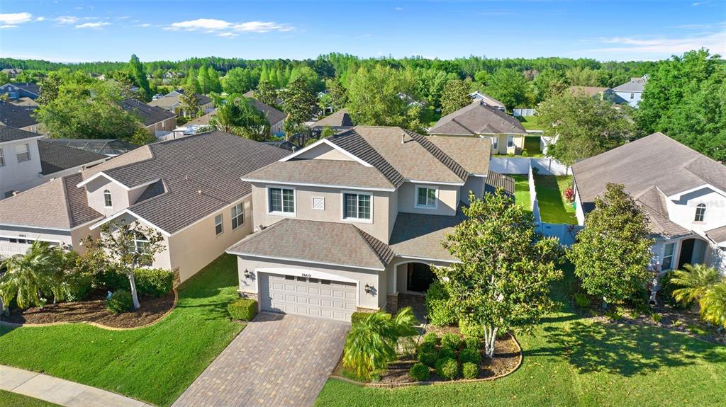 An aerial view of a two-story suburban house with a paved driveway and green lawn — 19419 RED SKY COURT, LAND O LAKES, FL