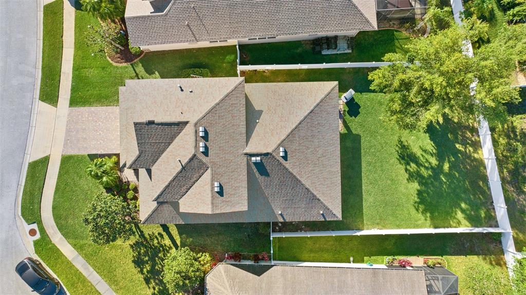An aerial view shows a residential house with a shingled roof and a large backyard — 19419 RED SKY COURT, LAND O LAKES, FL