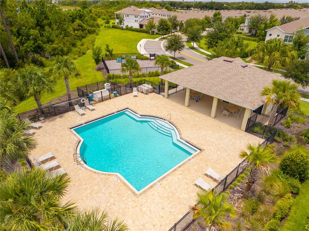An aerial view shows a swimming pool with a covered patio and surrounding lounge chairs — 8013 BASILICA LANE, WINTER GARDEN, FL