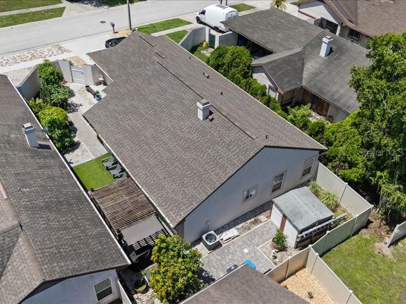 An aerial view shows a house with a shingled roof, a patio, and a small shed — 10903 LANDON LANE, TAMPA, FL