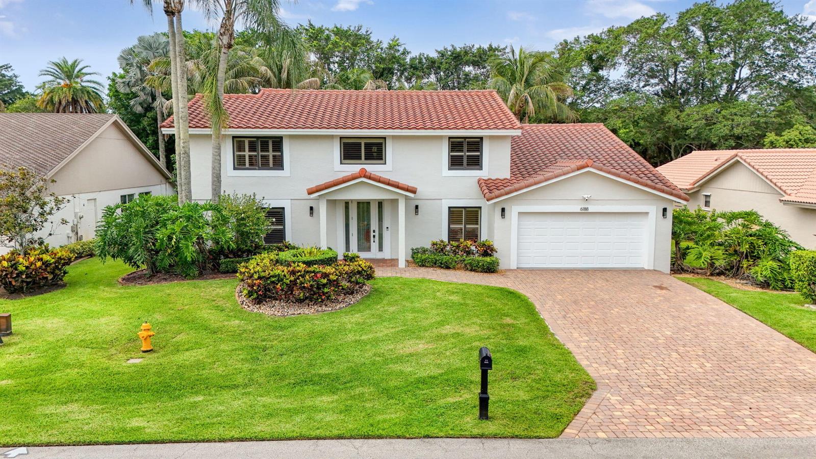 A two-story house with a red tile roof, white stucco exterior, and a brick driveway — 6188 Celadon Circle, Palm Beach Gardens FL 33418, PALM BEACH GARDENS, FL