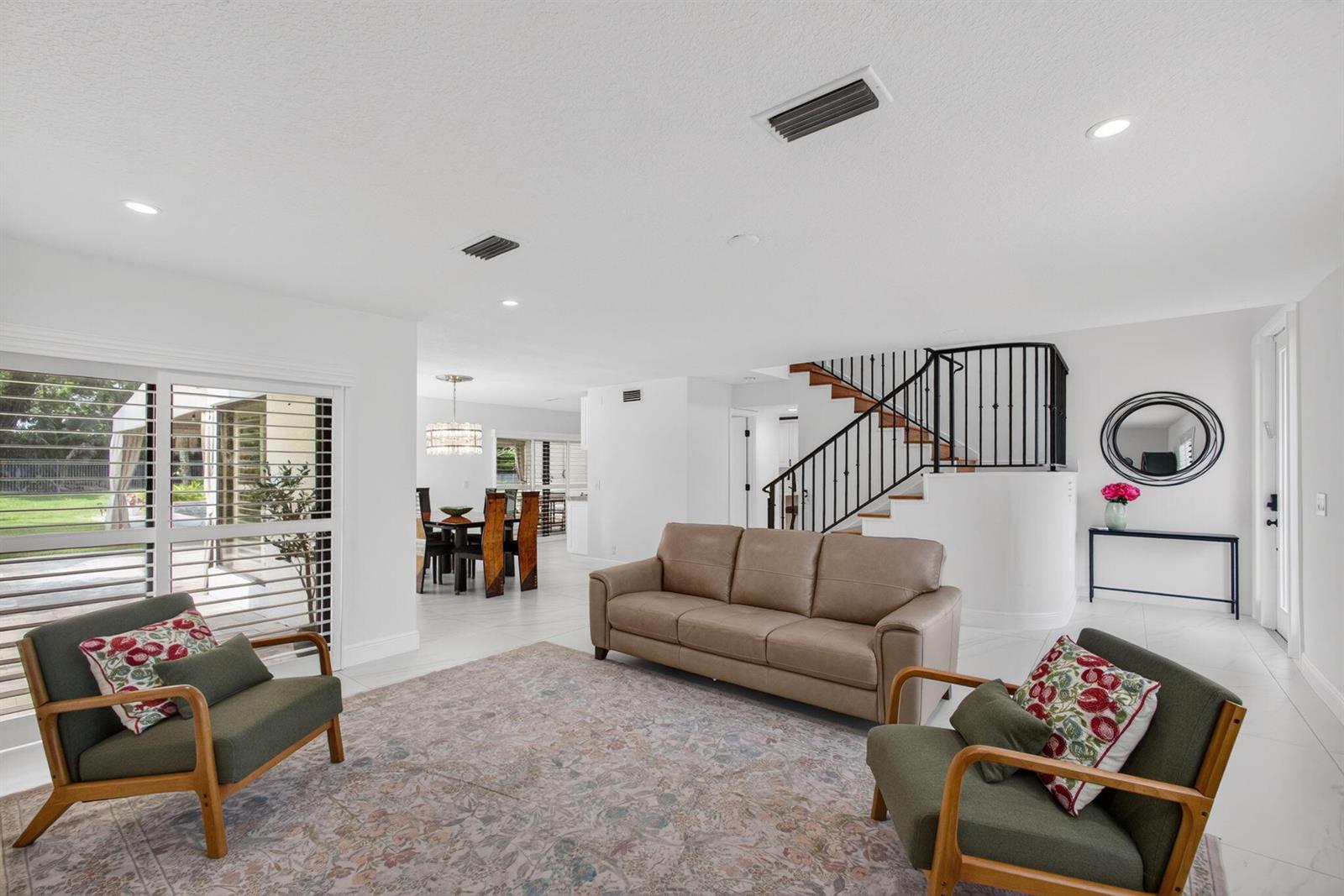 A living room with a beige sofa, two green armchairs, and a staircase — 6188 Celadon Circle, Palm Beach Gardens FL 33418, PALM BEACH GARDENS, FL