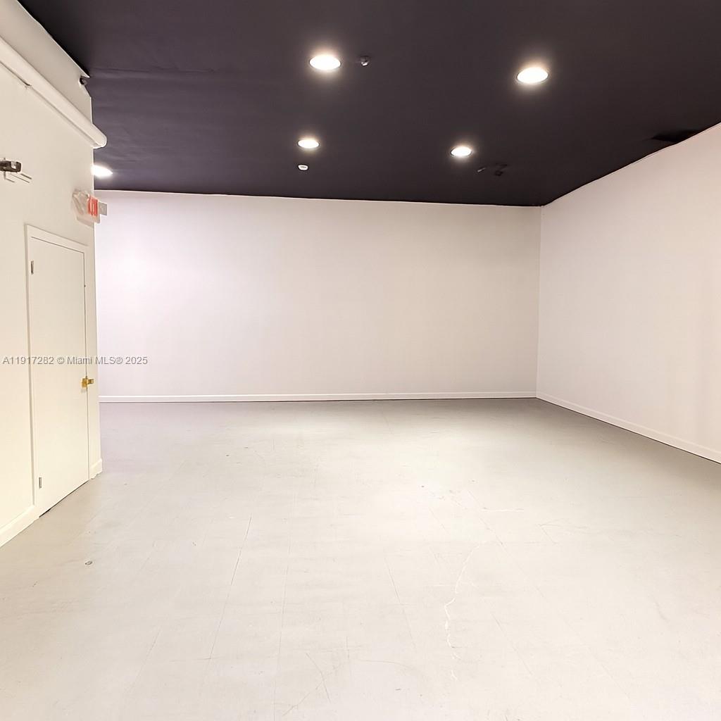 An empty room features white walls, a dark ceiling with recessed lighting, and gray flooring — 5798 SW 8th St, West Miami FL 33144, WEST MIAMI, FL