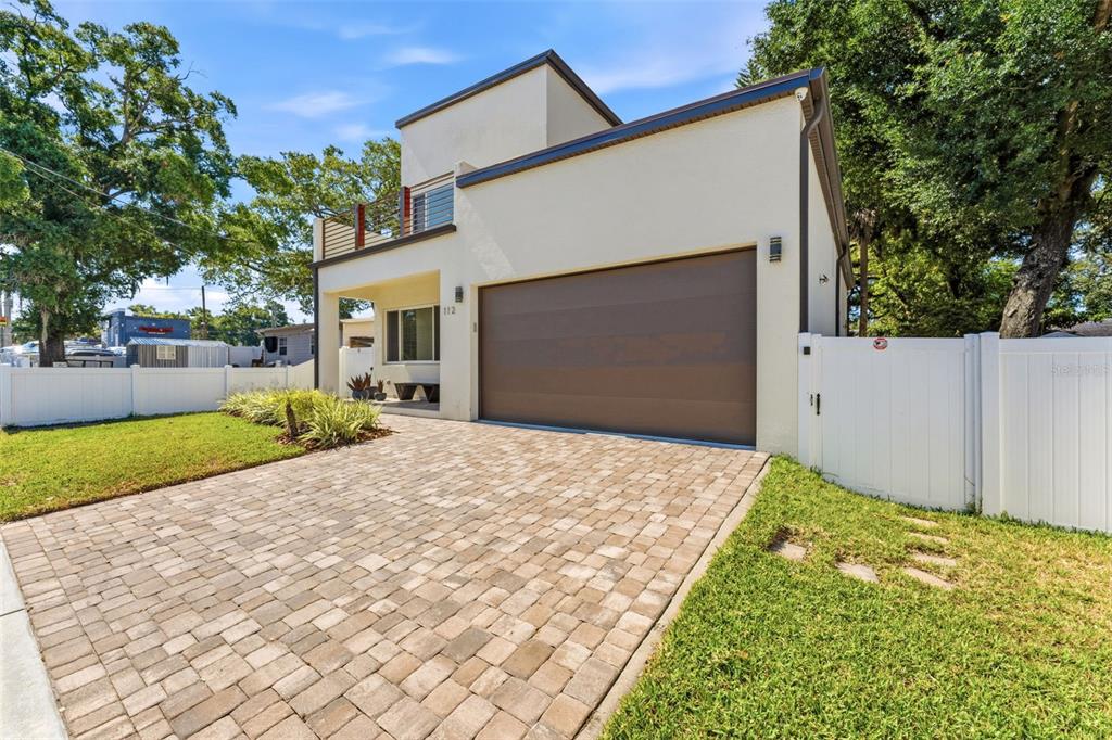 A two-story house with a paved driveway, a garage, and a second-floor balcony — 112 W SLIGH AVENUE, TAMPA, FL