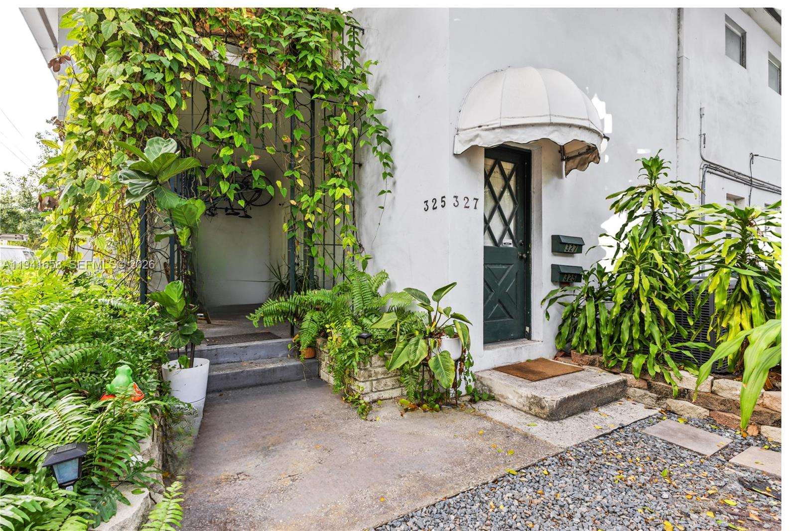 A two-story white building with a dirt driveway and lush landscaping under large trees — 325 Bird Rd, Coral Gables FL 33146, CORAL GABLES, FL