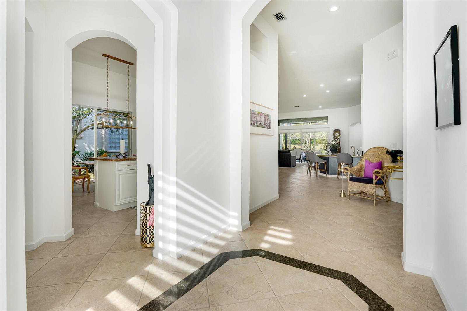 A bright, tiled entryway leads into an open-concept living area with arched architectural details — 10916 Northgreen Drive, Lake Worth FL 33449, LAKE WORTH, FL
