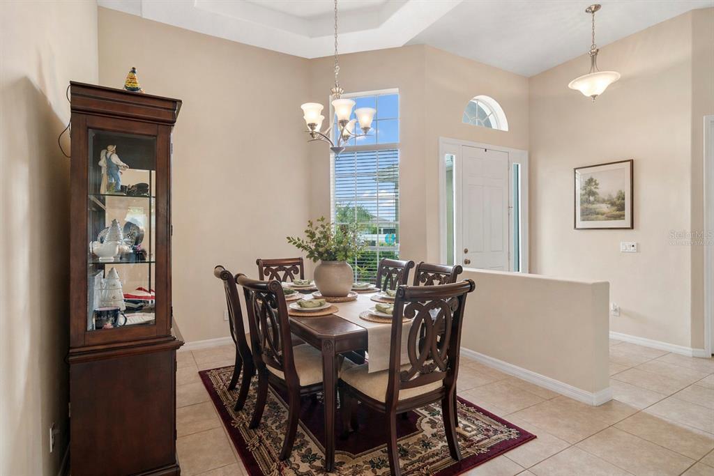 A paved walkway leads to the front entrance of a house with tan stucco walls — 925 BAINBRIDGE LOOP, WINTER GARDEN, FL