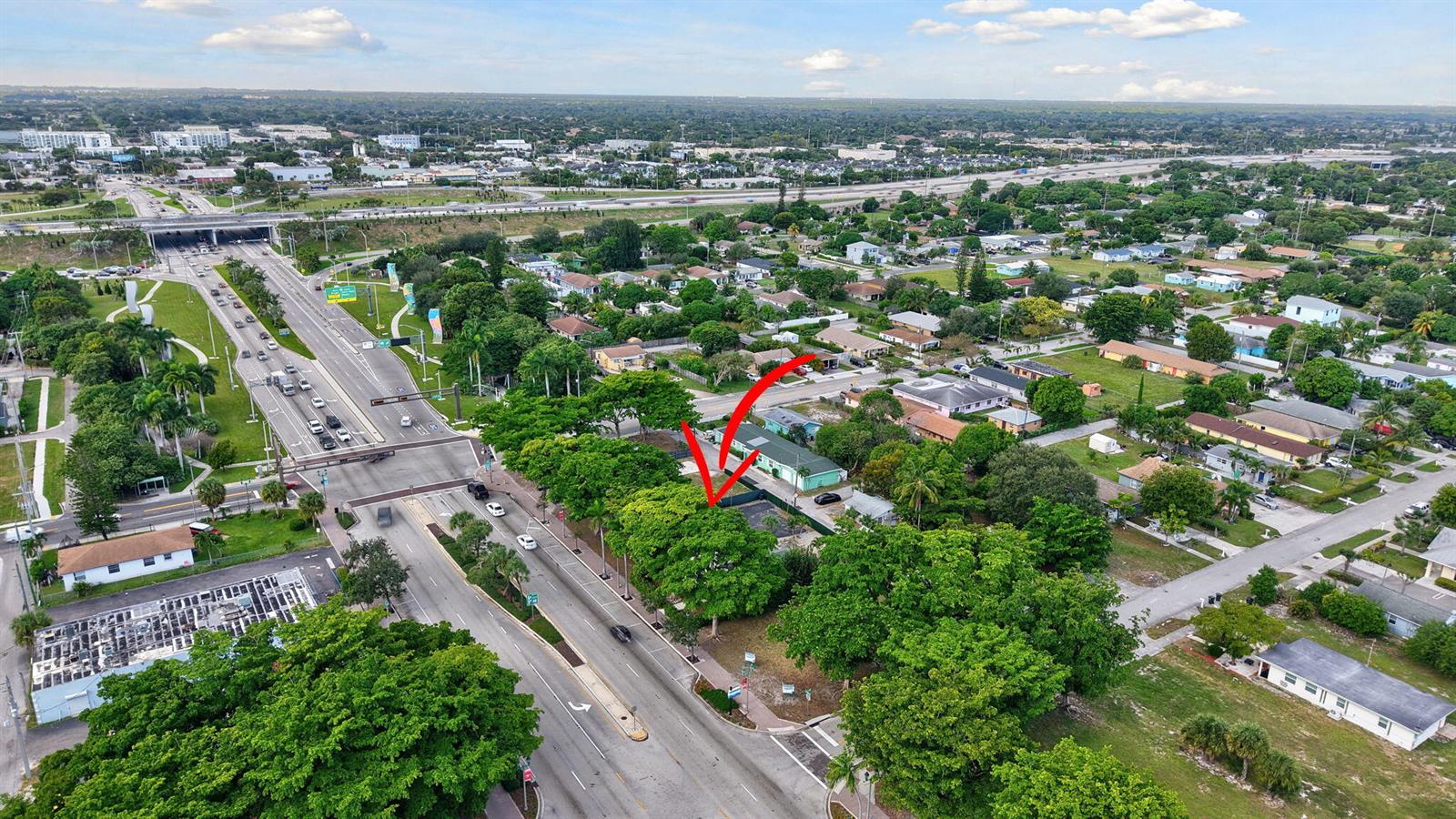 An aerial view shows a green building lot with mature trees next to a road — 0 W Atlantic Avenue, Delray Beach FL 33444, DELRAY BEACH, FL