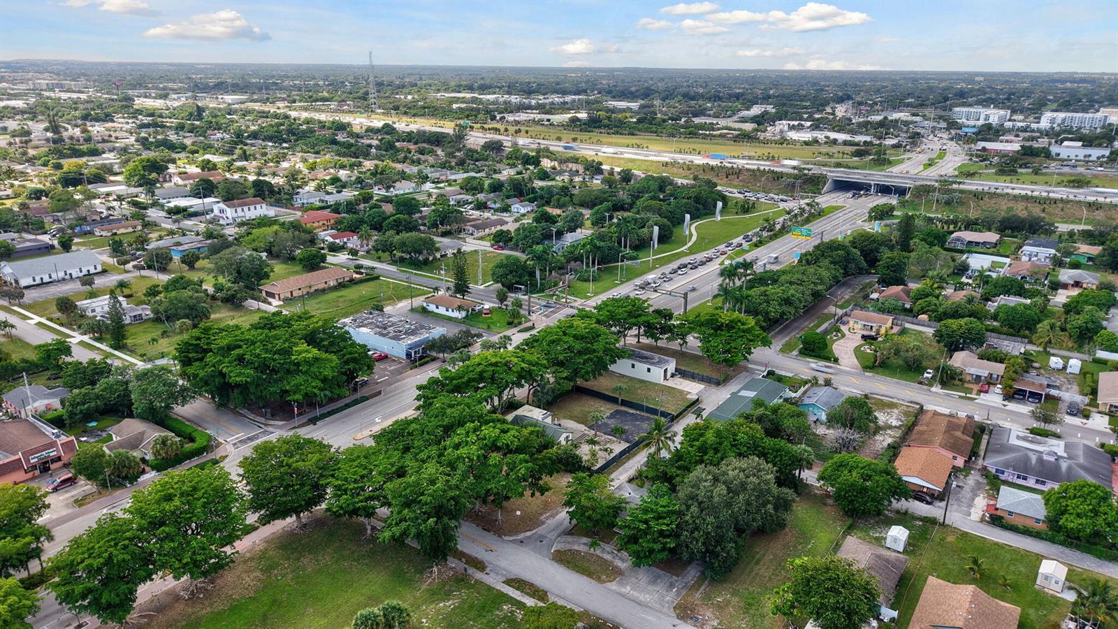 An aerial view shows a residential neighborhood with tree-lined streets and a nearby highway overpass — 0 W Atlantic Avenue, Delray Beach FL 33444, DELRAY BEACH, FL