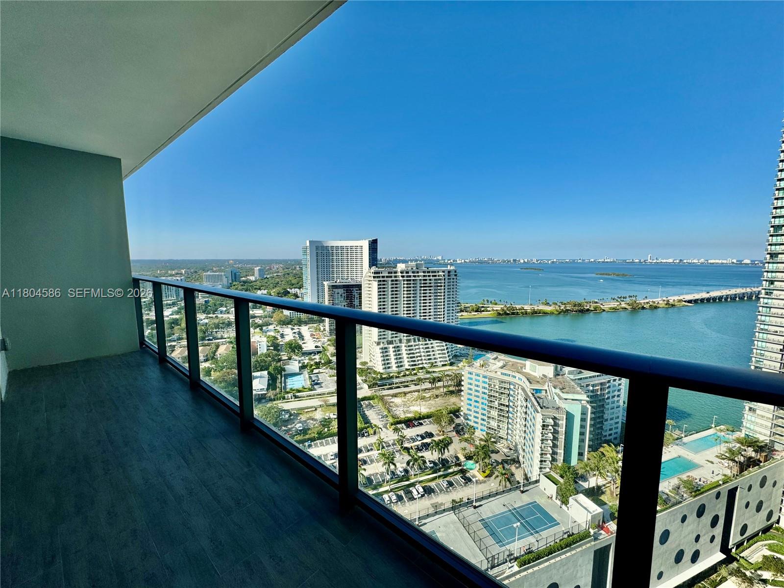 A high-rise balcony overlooks a city skyline, a bridge, and a large body of water — 501 NE 31st St # 2903, Miami FL 33137, MIAMI, FL